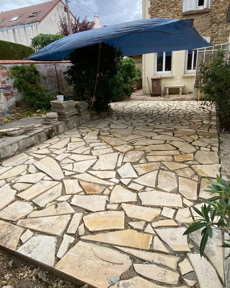 Después: Reformas: jardín de tierra convertido en patio de piedra natural